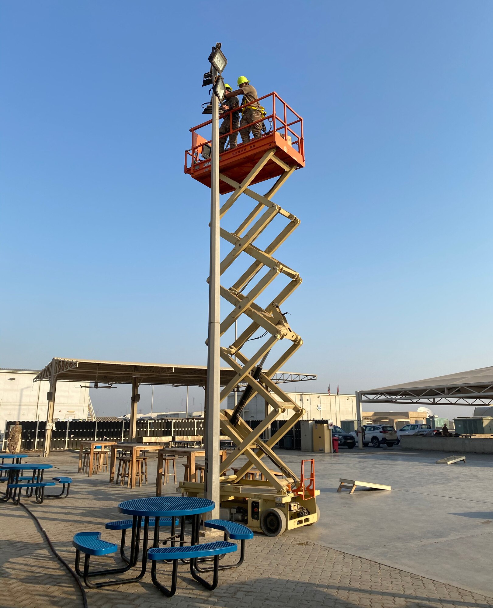 Members of the 380th Expeditionary Civil Engineer Squadron repair a light tower, July 7, 2020, at Al Dhafra Air Base, United Arab Emirates. The squadron is working on numerous projects to improve facilities and quality of life on base. (U.S. Air Force photo by Tech. Sgt. Melissa Harvey)