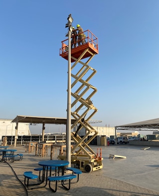 Members of the 380th Expeditionary Civil Engineer Squadron repair a light tower, July 7, 2020, at Al Dhafra Air Base, United Arab Emirates. The squadron is working on numerous projects to improve facilities and quality of life on base. (U.S. Air Force photo by Tech. Sgt. Melissa Harvey)