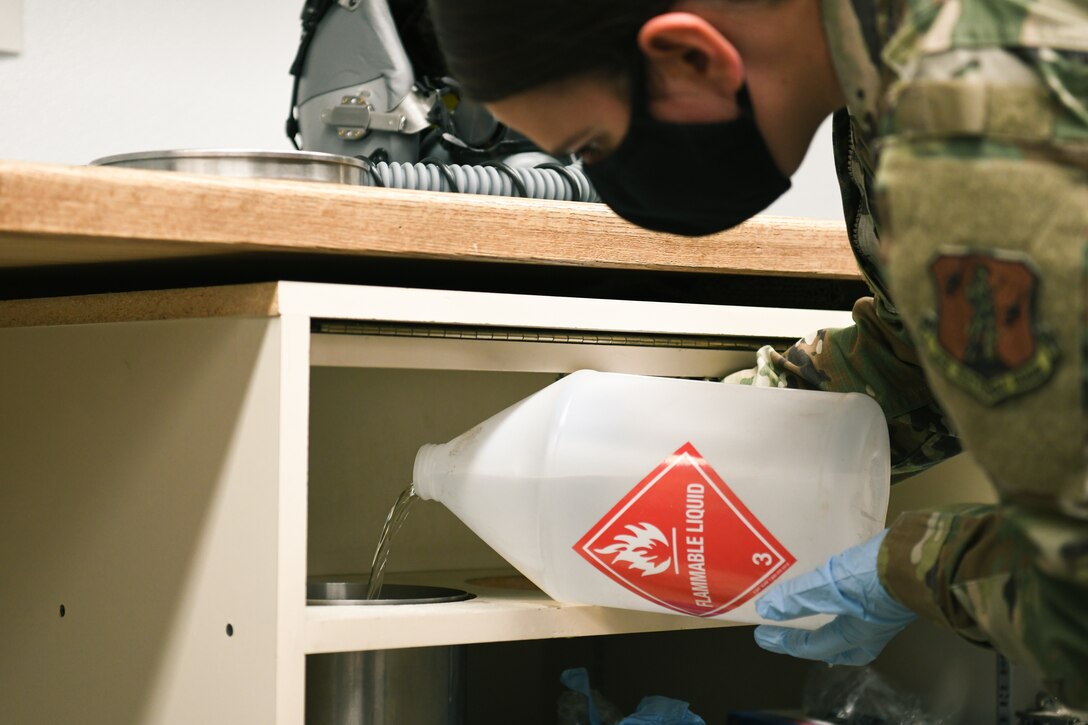 Airman fills container with isopropyl alcohol