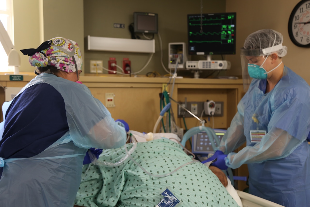 Army nurses provide medical care to a COVID-19 patient.