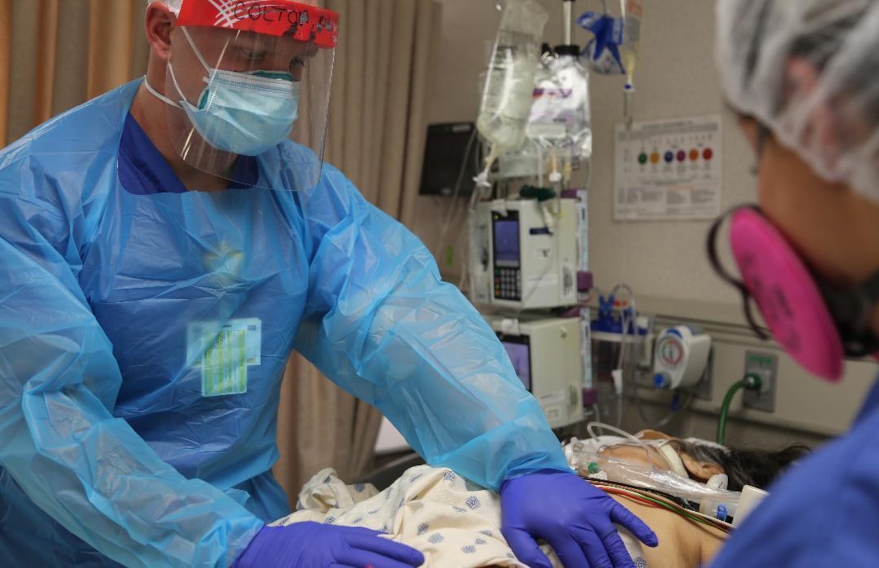 Army nurses provide medical care to a COVID-19 patient.