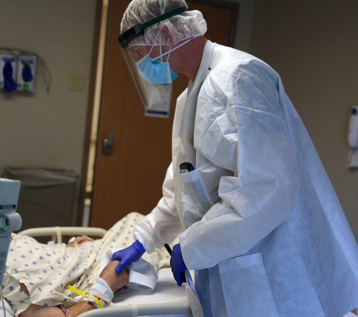 Army Sgt. Justin Hoffman, respiratory specialist from Urban Augmentation Medical Task Force-627, talks to a patient