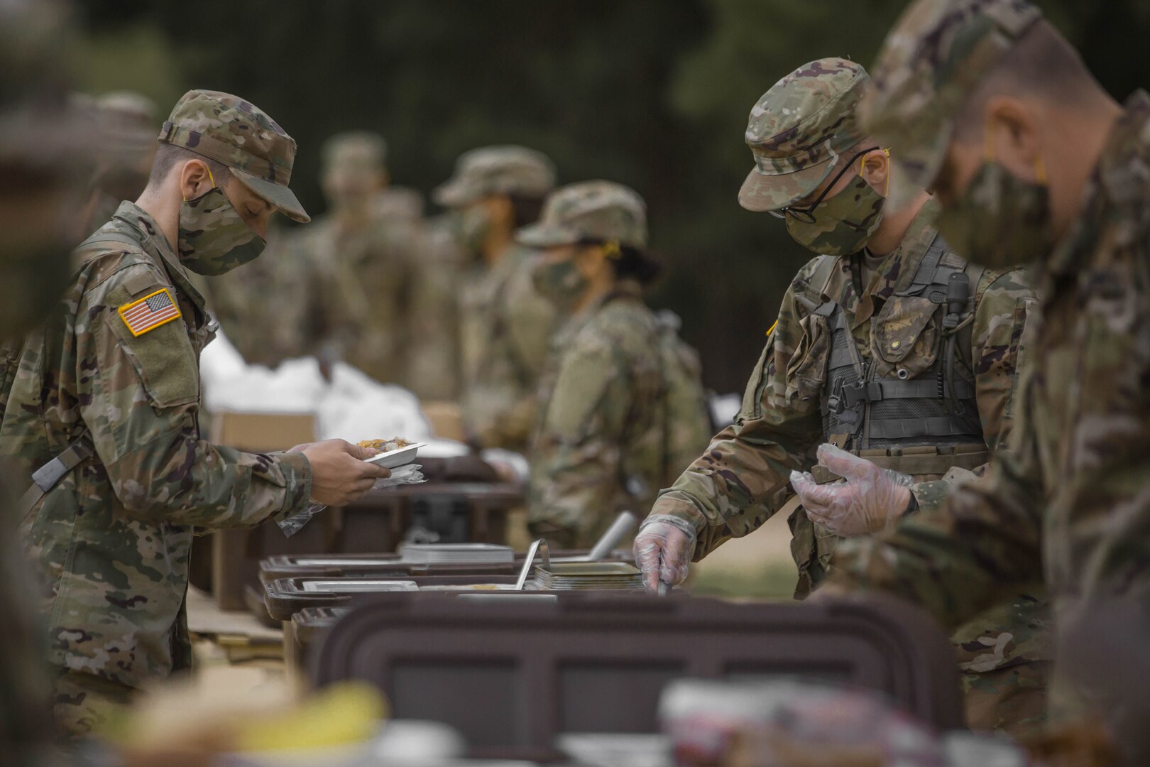 Soldiers in initial military training at Fort Jackson, South Carolina, line up to eat, May 11, 2020.