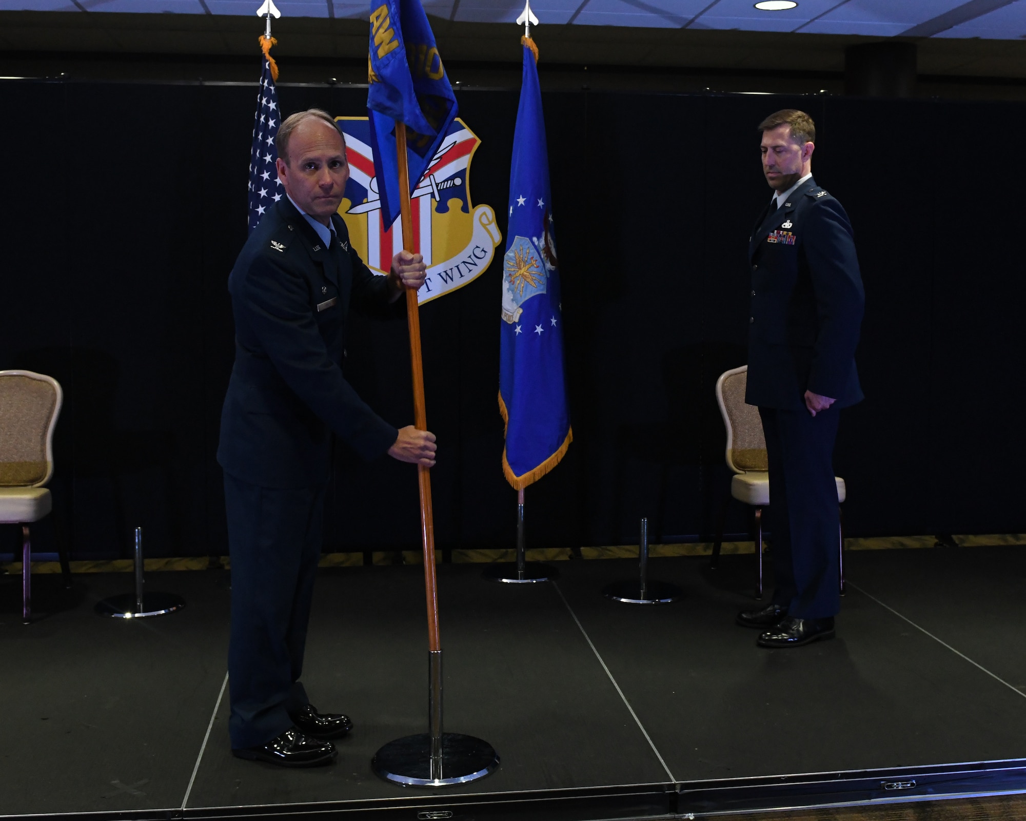 Col. Joe Janik, the 910th Airlift Wing commander, plants the 910th Mission Support Group guidon into a flag stand while Col. Meyer waits to receive it during an assumption of command at Youngstown Air Reserve Station, July 11, 2020. Meyer replaced the outgoing commander, Col. Don Wren.