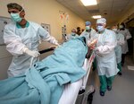 Members of the 555th Forward Surgical Team rush a simulated trauma patient to surgery during training with the Strategic Trauma Readiness Center of San Antonio, or STaRC, at Brooke Army Medical Center.