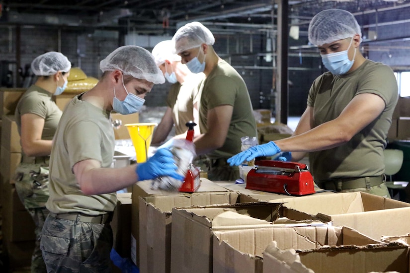 National Guardsmen pack boxes of food for distribution during the COVID-19 pandemic.