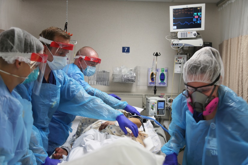 Medical staff work on a patient in a hospital room.