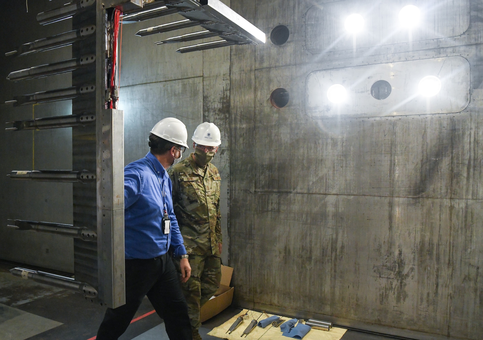 Scott Meredith, left, technical advisor for Arnold Engineering Development Complex (AEDC) Flight Systems Branch, and Chief Master Sgt. Stanley Cadell, command chief, Air Force Materiel Command, walk past a rake installed in a test section of the 16-foot supersonic wind tunnel, which is used to characterize the flow in the tunnel, during a tour July 8, 2020, at Arnold Air Force Base, Tenn., headquarters of AEDC. The visit to the Base by Cadell and Gen. Arnold W. Bunch Jr., commander, Air Force Materiel Command, focused on COVID-19 response, and diversity and inclusion. (U.S. Air Force photo by Jill Pickett) (This image has been altered by obscuring a badge for security purposes.)