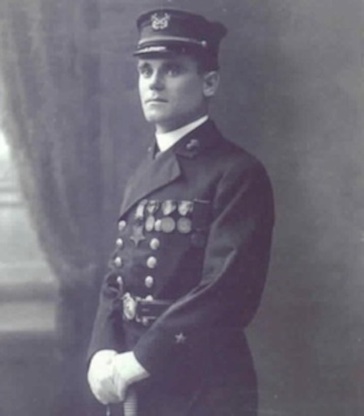 A man in a uniform stands for a photo.