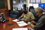 Capt. Cedric McNeal, commanding officer of Naval Surface Warfare Center, Carderock Division, and Technical Director Larry Tarasek sign an Education Partnership Agreement from their office in West Bethesda, Md.