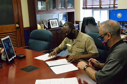 Capt. Cedric McNeal, commanding officer of Naval Surface Warfare Center, Carderock Division, and Technical Director Larry Tarasek sign an Education Partnership Agreement from their office in West Bethesda, Md.
