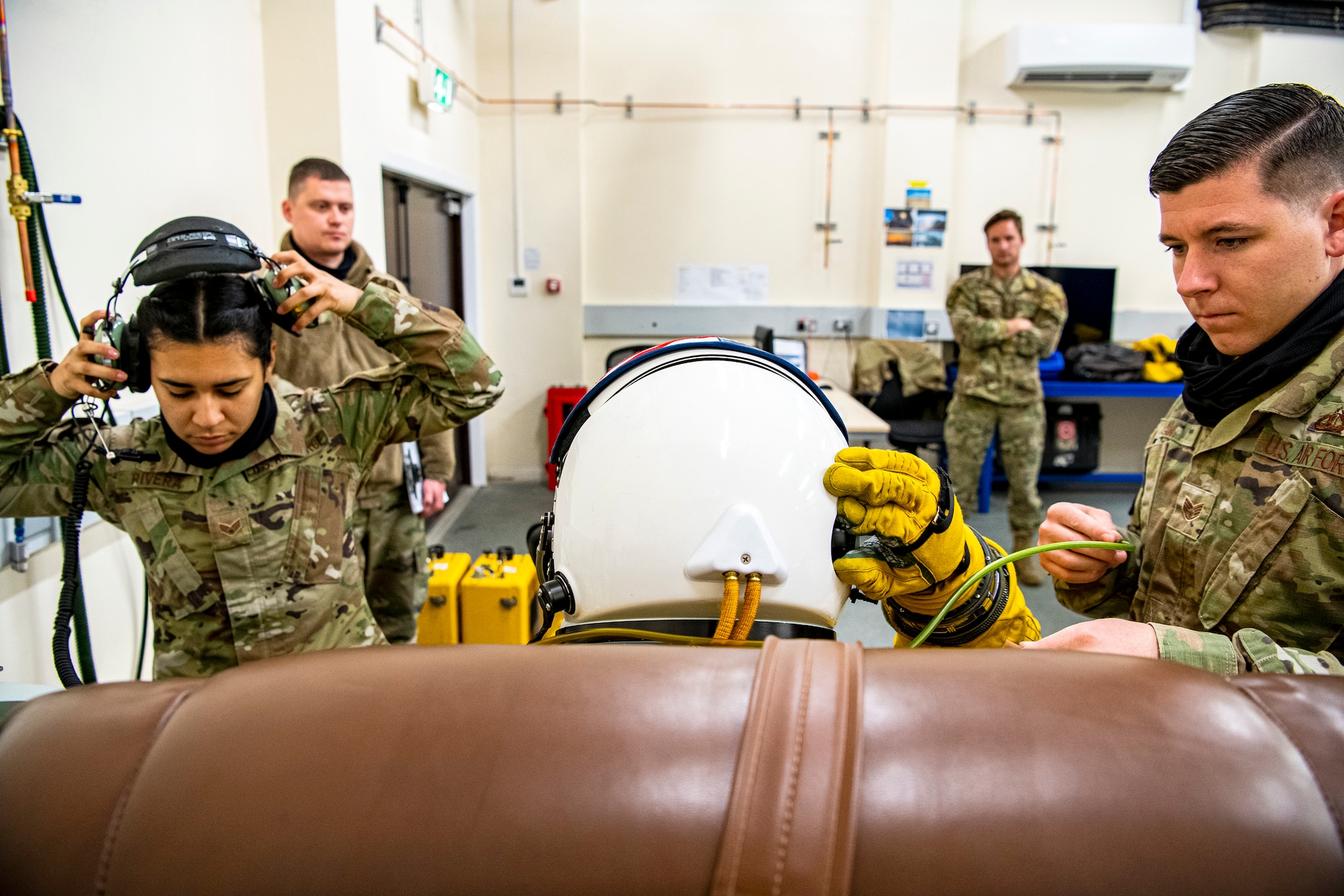 U.S. Air Force Staff Sgt. Nicholas Law, right, 99th Expeditionary Reconnaissance Squadron (ERS) aircrew flight equipment technician, assists Capt. Joshua Hall, center 99th RS U-2 Dragon Lady pilot, with his suit preparations at RAF Fairford, England, July 8, 2020. The U-2 aircraft assigned to the 9th Reconnaissance Wing, Beale Air Force Base, Calif., are currently deployed to RAF Fairford as part of the 99th ERS. The U.S. Air Force is engaged, postured and ready with credible force to assure, deter and defend in an increasingly complex security environment. (U.S. Air Force photo by Senior Airman Eugene Oliver)