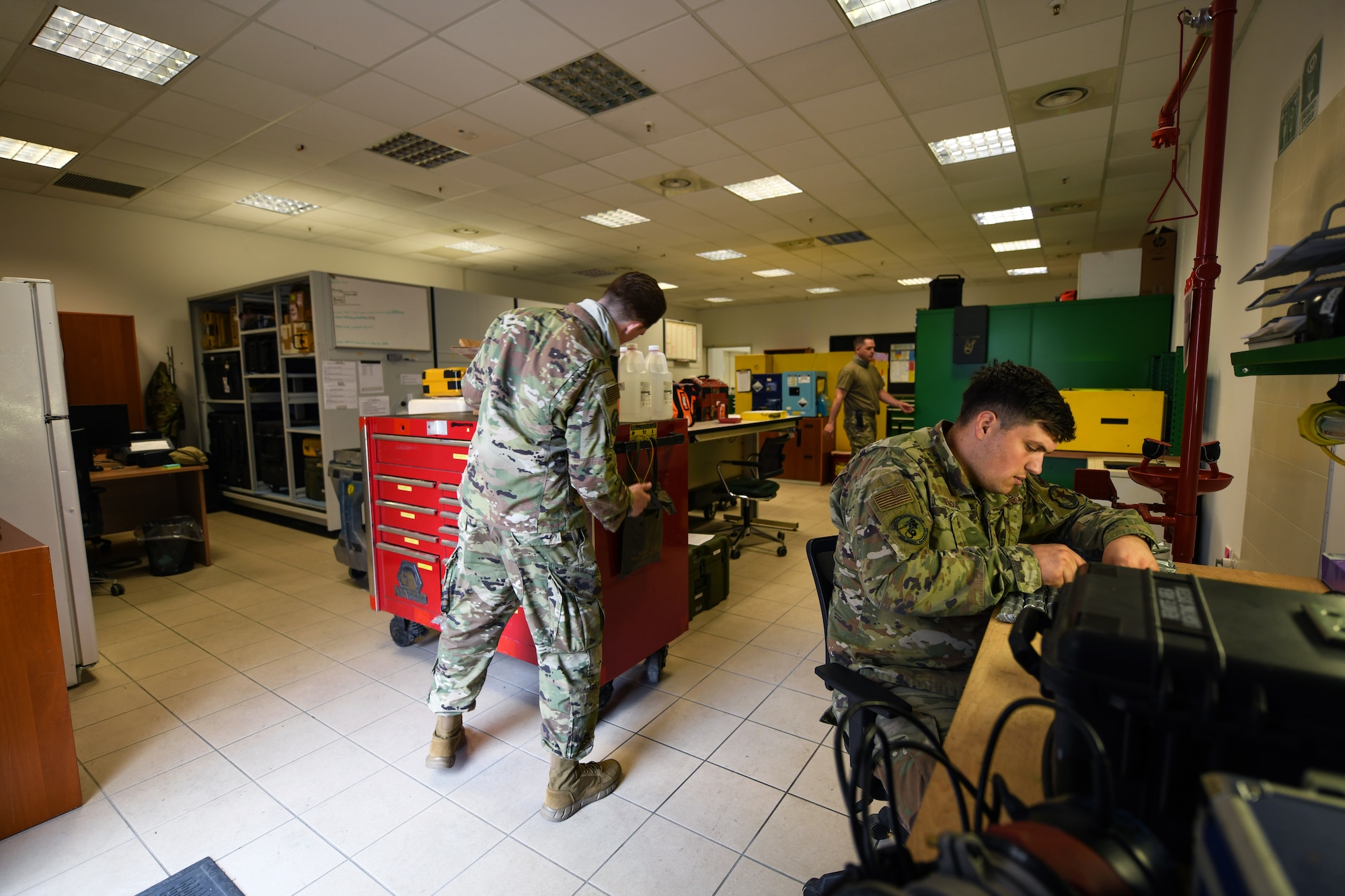 U.S. Air Force Staff Sgt. Edward T. Sims (left), support craftsman, U.S. Air Force Tech. Sgt. Kenneth Hopkins (center), support section chief, and U.S. Air Force Senior Airman Jeremiah Reynolds (right), support journeyman, work in the new support section of hangar three at Aviano Air Base, Italy, July 14, 2020. Sims, Hopkins, and Reynolds are assigned to the 31st Aircraft Maintenance Squadron, 56th Helicopter Maintenance Unit. (U.S. Air Force photo by Airman 1st Class Ericka A. Woolever)