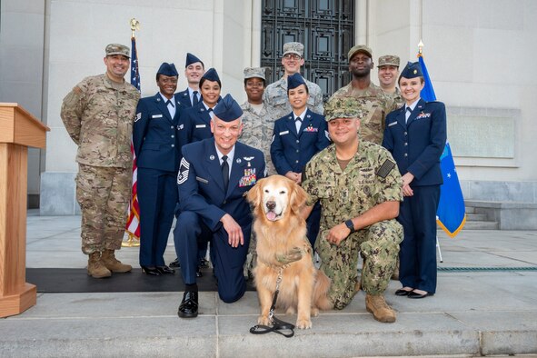 Group photo with Chief Master Sgt. G. "Steve" Cum, Chief, Medical Enlisted Force, posing with Lt. Col. Goldie, a U.S. Air Force therapy dog, and other service members from Walter Reed National Military Medical Center.