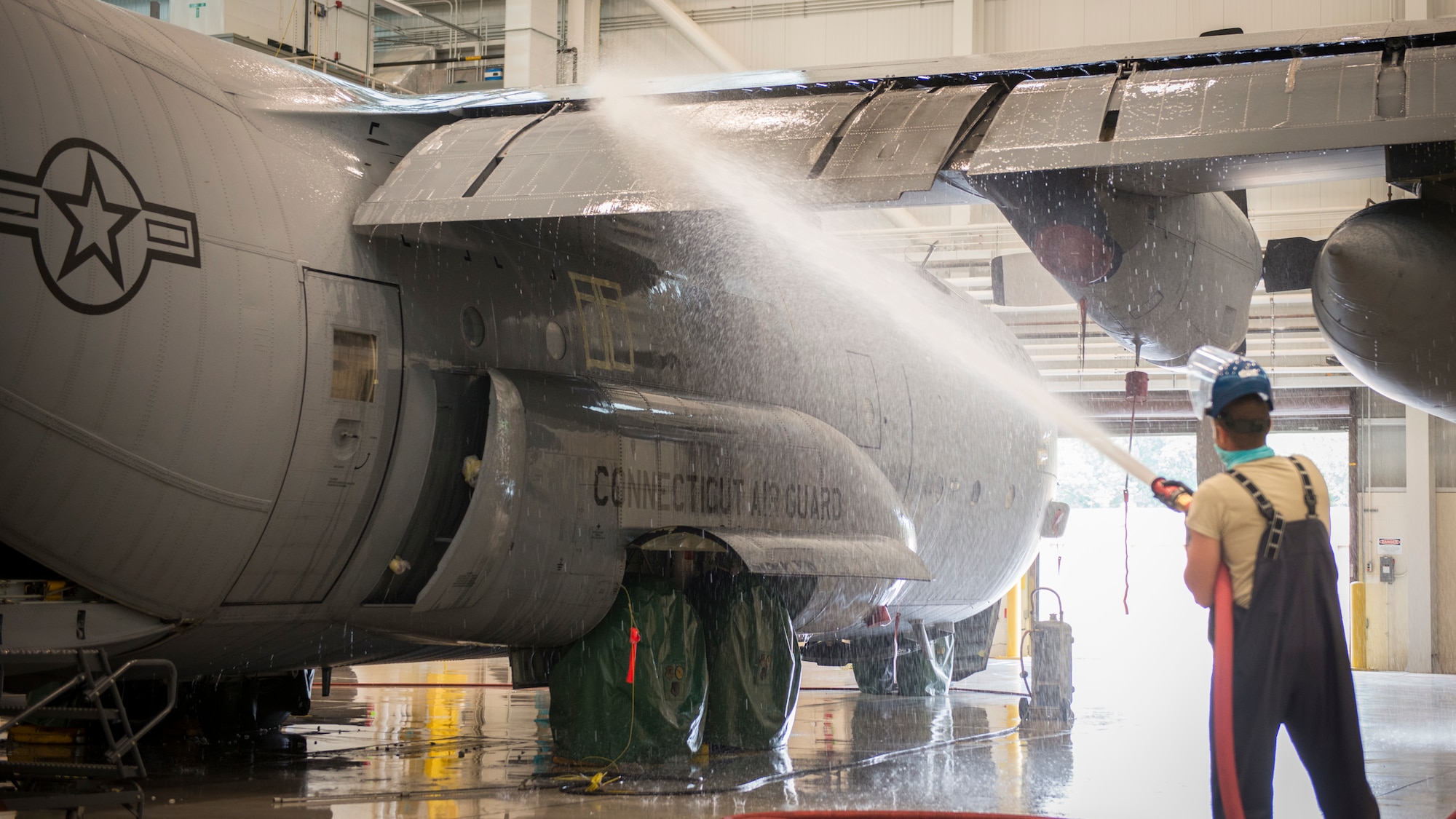 Airman 1st Class A.J. Raffles, 103rd Maintenance Squadron structural maintenance specialist, washes a C-130H Hercules at the Bradley Air National Guard Base fuel cell and corrosion control facility in East Granby, Connecticut, July 13, 2020. Each of the 103rd Airlift Wing’s eight C-130 aircraft are washed every six months to clean contaminants and prevent corrosion, ensuring aircraft readiness and extending its life cycle. (U.S. Air National Guard photo by Staff Sgt. Steven Tucker)