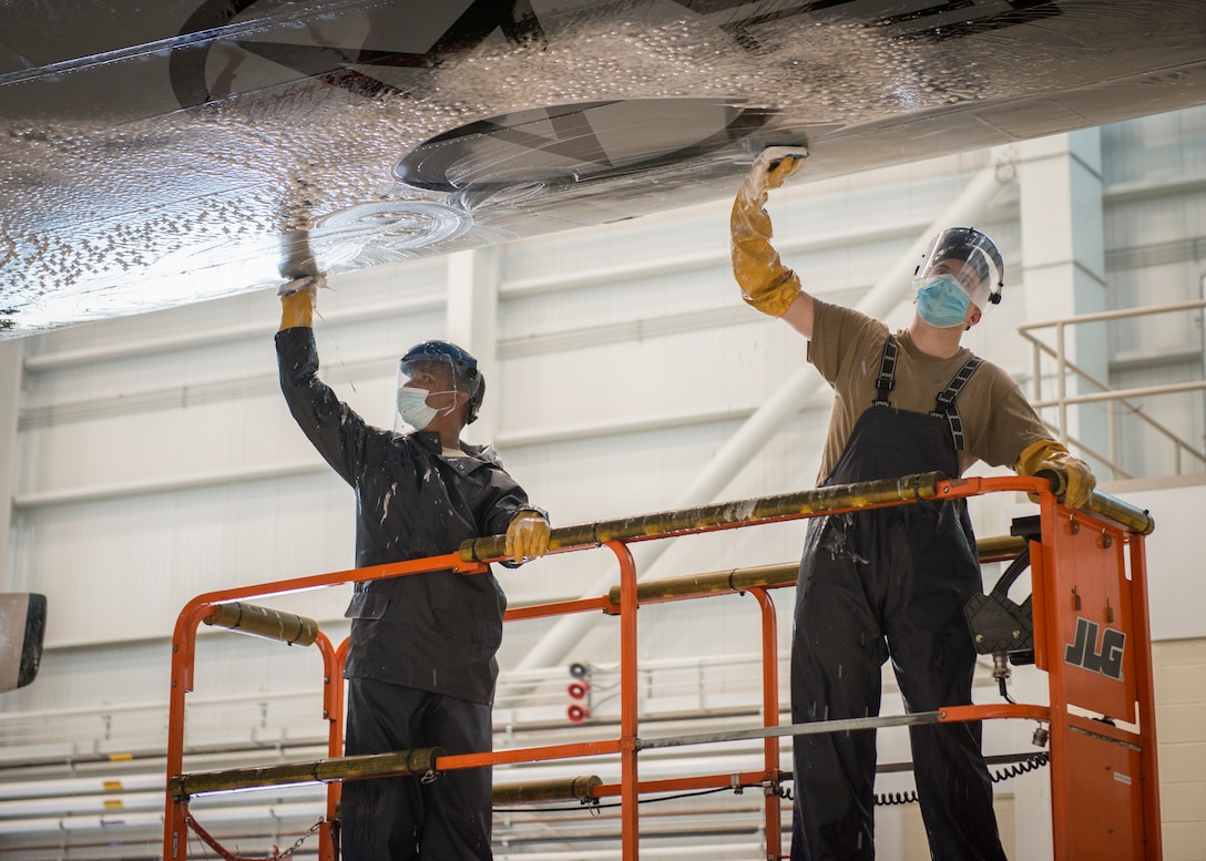 Airman 1st Class Mckenzie Rosemond (left), 103rd Maintenance Squadron avionics technician, and Senior Airman Zachary Beane, 103rd Maintenance Squadron, scrub the wing of a C-130H Hercules during an aircraft wash at the Bradley Air National Guard Base fuel cell and corrosion control facility in East Granby, Connecticut, July 13, 2020. Each of the 103rd Airlift Wing’s eight C-130 aircraft are washed every six months to clean contaminants and prevent corrosion, ensuring aircraft readiness and extending its life cycle. (U.S. Air National Guard photo by Staff Sgt. Steven Tucker)