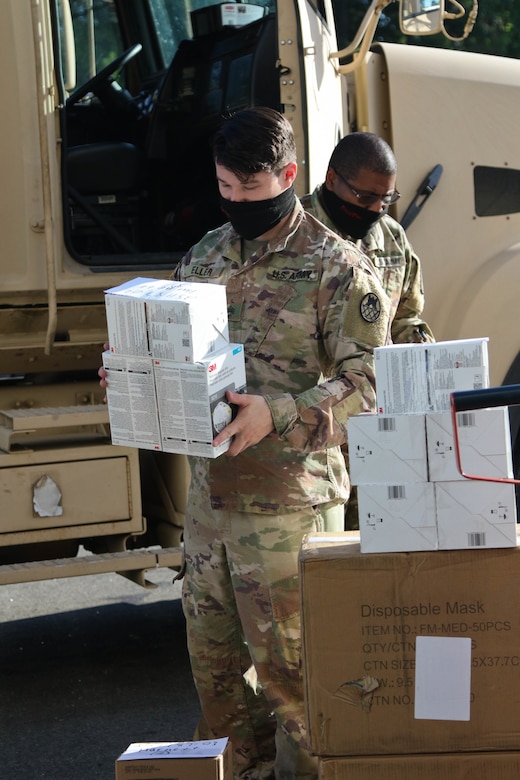 National Guardsmen load boxes of food into a vehicle.