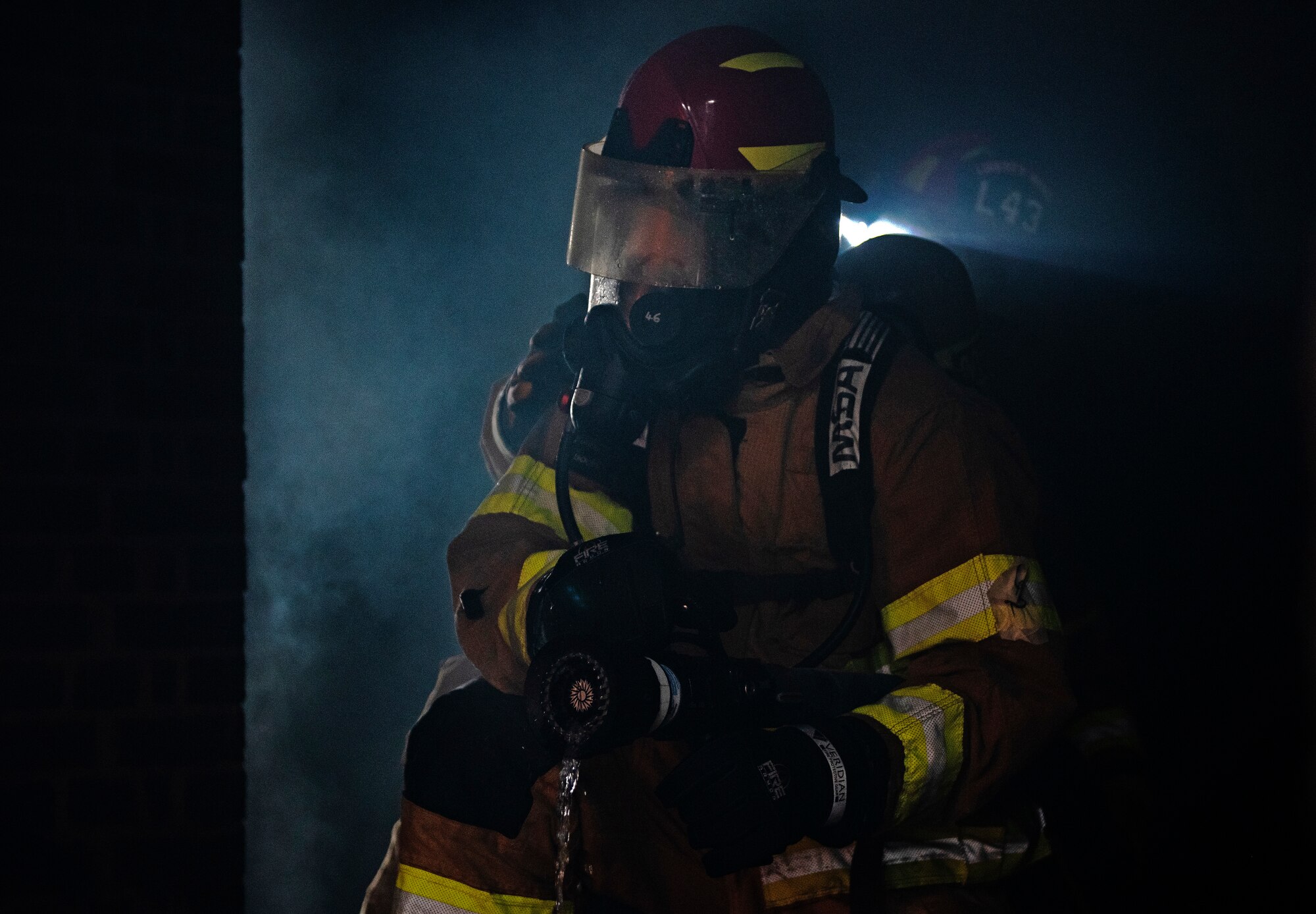 A U.S. Air Force firefighter assigned to the 48th Civil Engineering Squadron extinguishes a fire inside the structural training facility during a controlled burn training exercise at Royal Air Force Lakenheath, England, July 8, 2020. Structural training exercises allow Liberty Wing firefighters to improve communication and teamwork in low visibility, high stress environments. (U.S. Air Force photo by Airman 1st Class Jessi Monte)