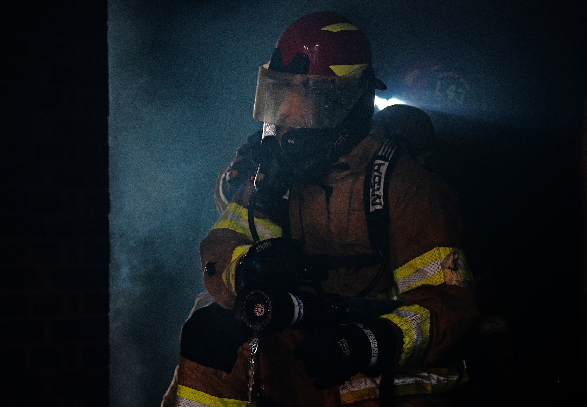 A U.S. Air Force firefighter assigned to the 48th Civil Engineering Squadron extinguishes a fire inside the structural training facility during a controlled burn training exercise at Royal Air Force Lakenheath, England, July 8, 2020. Structural training exercises allow Liberty Wing firefighters to improve communication and teamwork in low visibility, high stress environments. (U.S. Air Force photo by Airman 1st Class Jessi Monte)