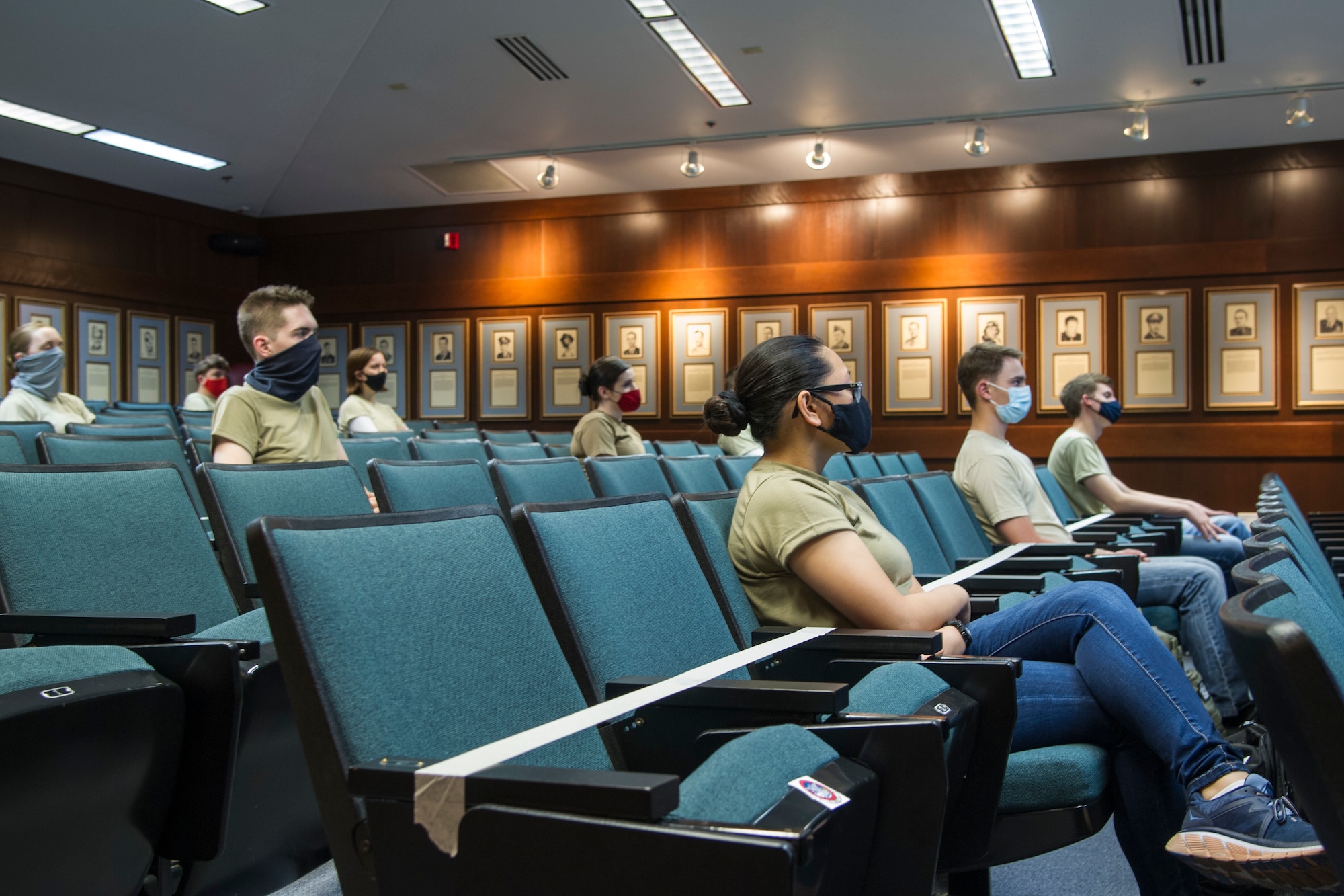 Air Force Reserve trainees sit in a room wearing face coverings