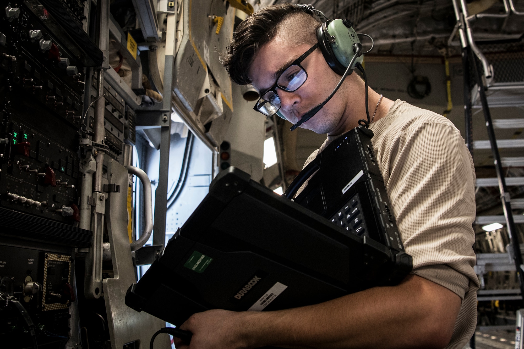 Photo of an Airman reviewing instructions for a C-17 Globemaster III inspection.