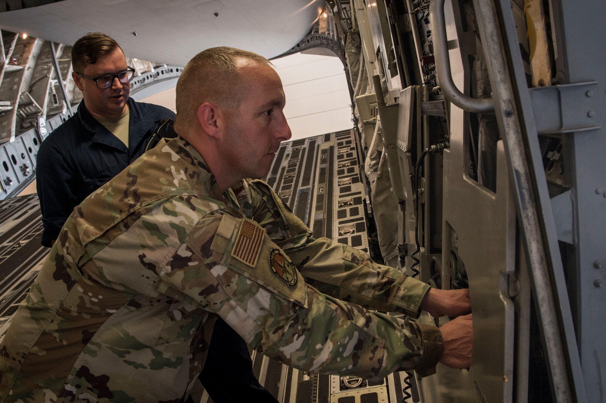 Photo of an Airman testing a loading ramp C-17 Globemaster III during an inspection.