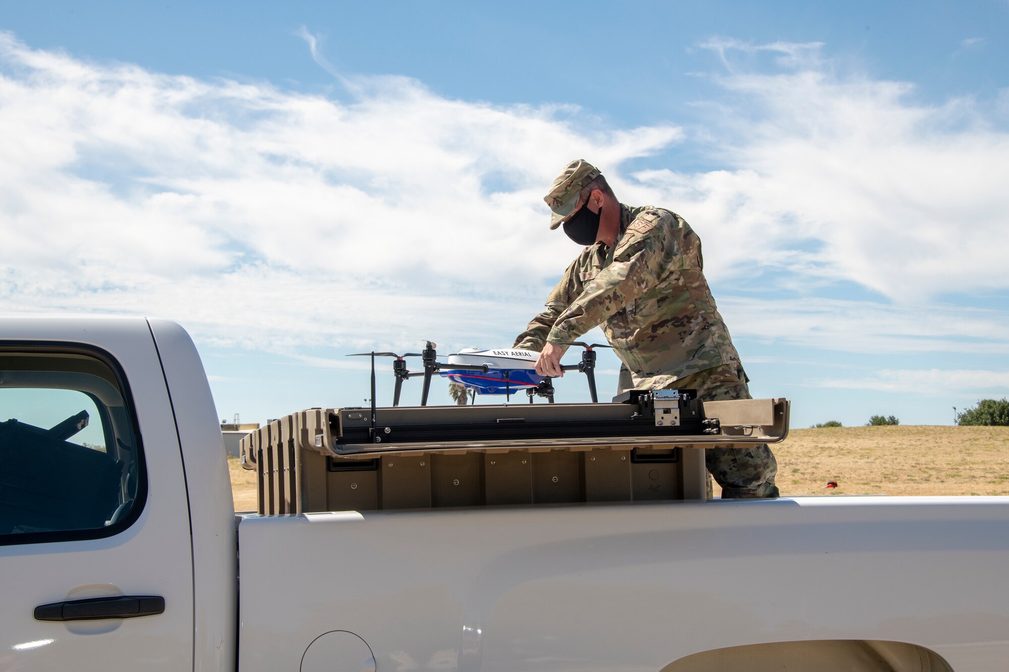U.S. Air Force Master Sgt. Joshua Hicks, 60th Security Forces Squadron flight chief, secures an Easy Aerial drone inside of the ground charging station July 10, 2020, at Travis Air Force Base, California. The mobile and fully autonomous drone-based monitoring system enhances 60th SFS incident management and physical security of the base.