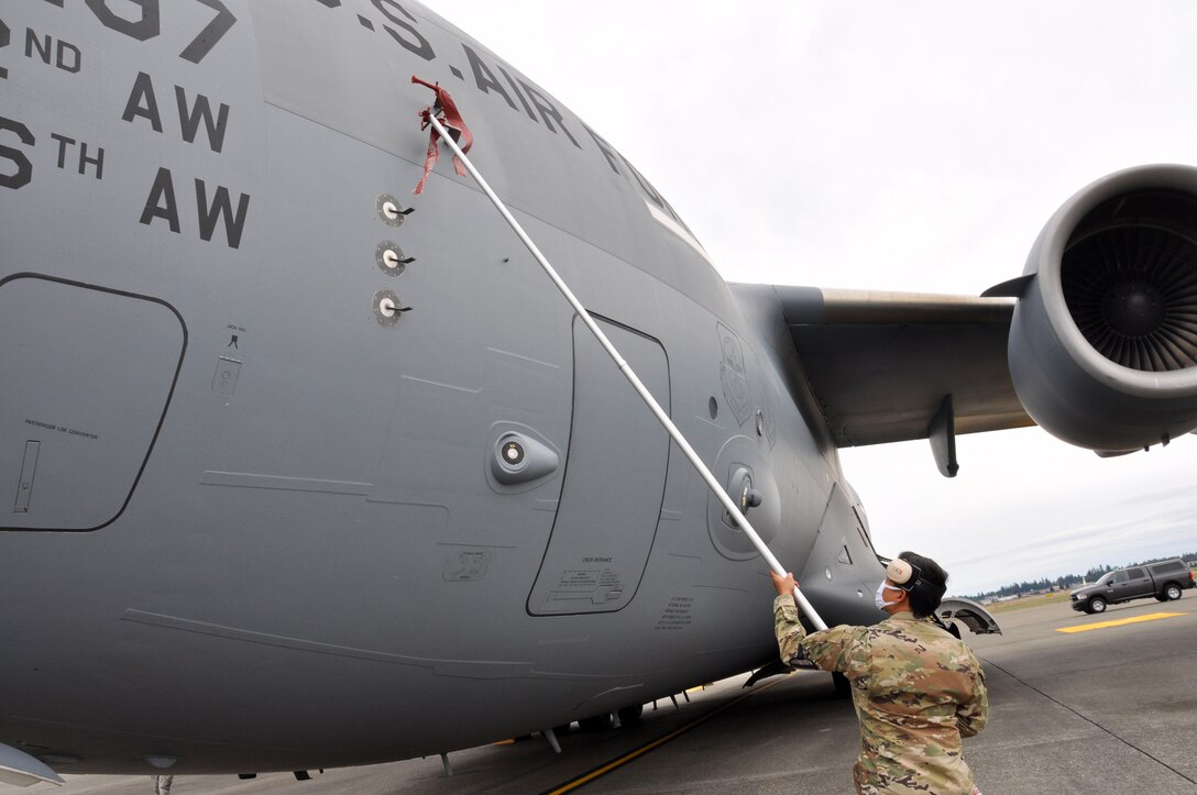 Airman hangs red tags on aircraft