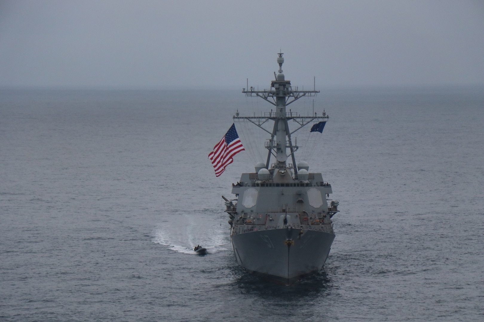 A rigid-hull inflatable boat comes alongside USS Halsey.