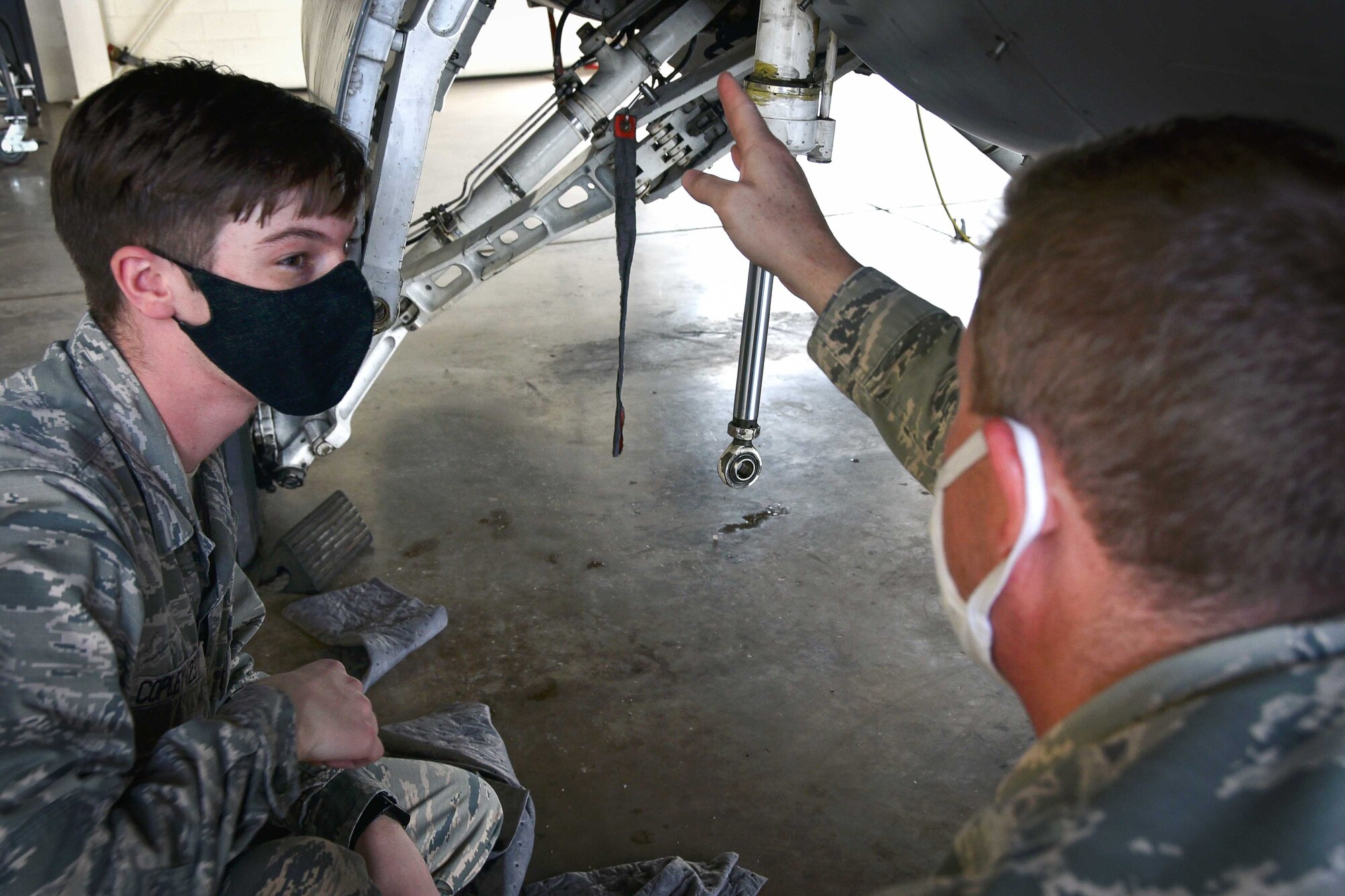 U.S. Air Force Maj. Kelly Ryan, 301st Fighter Wing Aircraft Maintenance Squadron maintenance operations officer, instructs U.S. Air Force Academy Cadet 3rd Class Bennett Copley on specific wiring components of an F-16 Fighting Falcon on July 8, 2020 at U.S. Naval Air Station Joint Reserve Base Fort Worth, Texas. Copley experienced total force integration by not only working with Reservists but also the Active Duty Airmen stationed here with the 24th Fighter Squadron, an active associate of the wing. (U.S. Air Force photo by Senior Airman Kedesha Pennant)