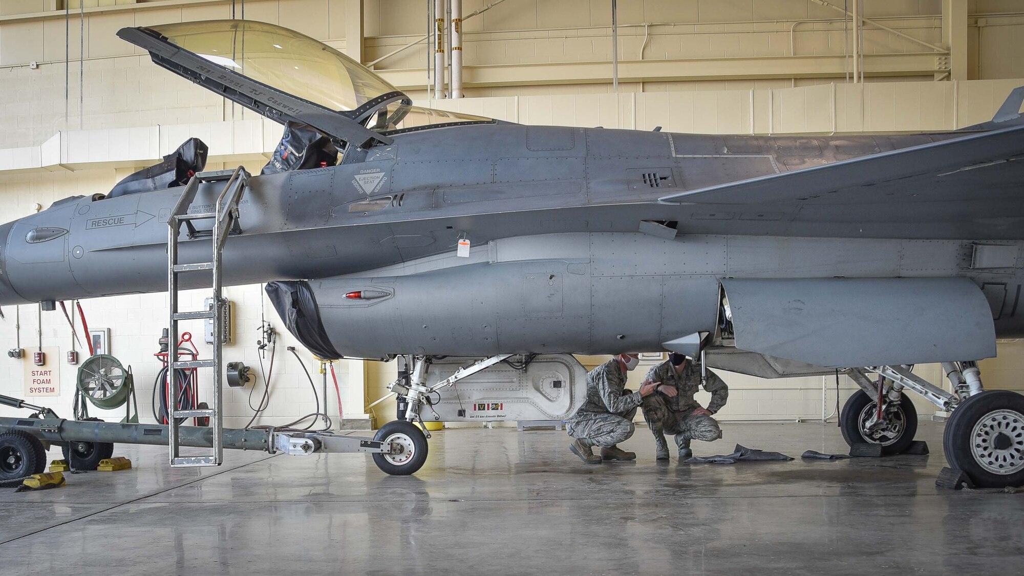 U.S. Air Force Maj. Kelly Ryan, 301st Fighter Wing Aircraft Maintenance Squadron maintenance operations officer, and U.S. Air Force Academy Cadet 3rd Class Bennett Copley inspect the results of a hydraulic leak fix on a F-16 Fighting Falcon, July 8, 2020 at U.S. Naval Air Station Joint Reserve Base Fort Worth, Texas. Copley, who aims to be a fighter pilot, received the opportunity to shadow the 301 FW Aircraft Maintenance Squadron to gain a better understanding of what Reserve Airmen do to keep jets in the air. (U.S. Air Force photo by Senior Airman Kedesha Pennant)
