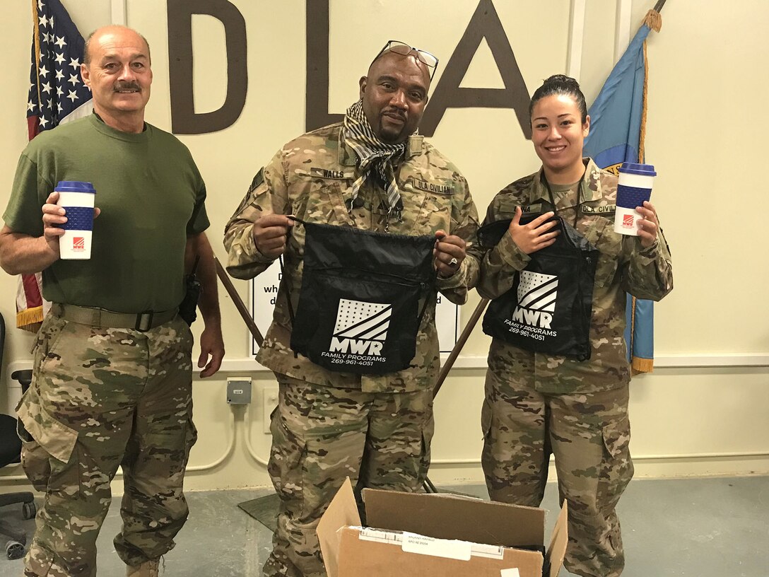 Larry Leach, left. Andrew Walls, center, and Justina Luna show off thier MWR care package items
