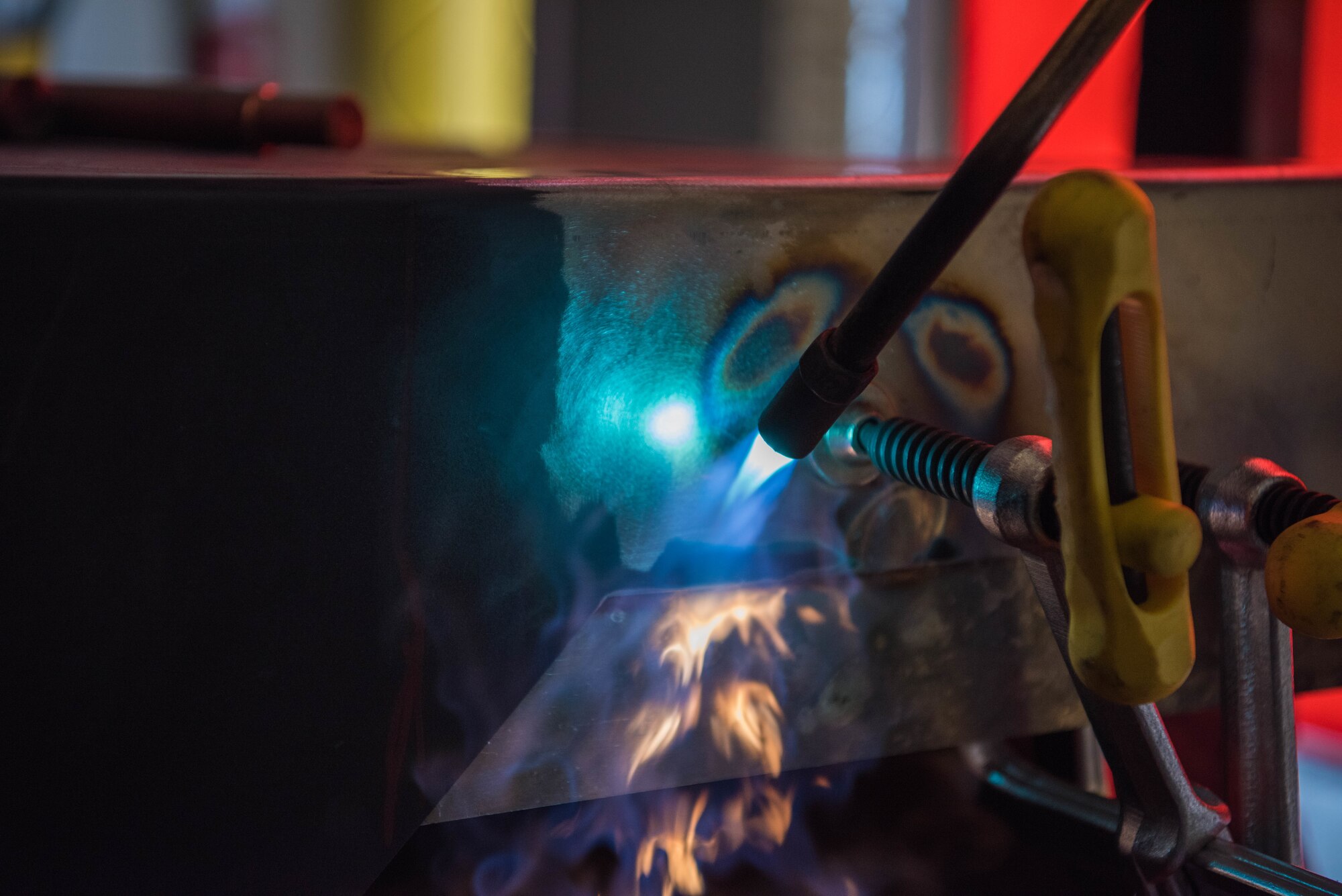 Flames from an oxygen acetylene torch soften the steel frame on a mobile aircraft generator July 9, 2020, at McConnell Air Force Base, Kansas. Metals technology Airmen use heat to manipulate the steel frame to its original form to support the stability of the frame. (U.S. Air Force photo by Airman 1st Class Marc A. Garcia)