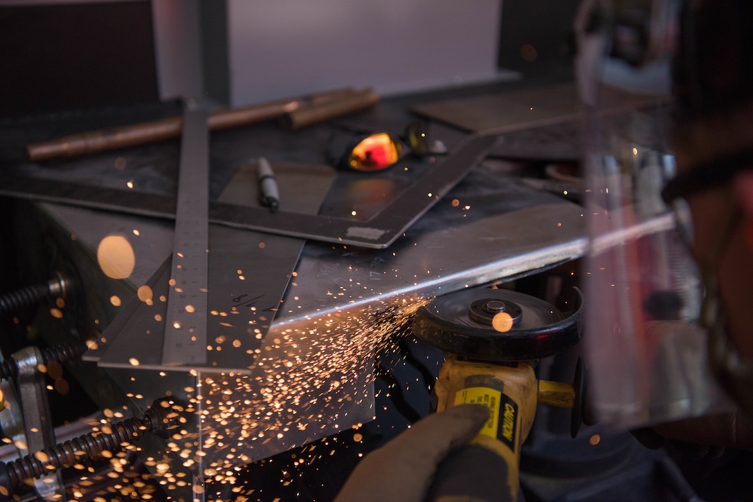 Senior Airman Jay Powell, 22nd Maintenance Squadron metals technology journeyman, uses a grinder to remove excess metal July 9, 2020, at McConnell Air Force Base, Kansas. The grinder allows Airmen to make precision cuts on metal. The grinder also enables Airmen to get their measurements within one-sixteenths of an inch of space needed to fix equipment. (U.S. Air Force photo by Airman 1st Class Marc A. Garcia)