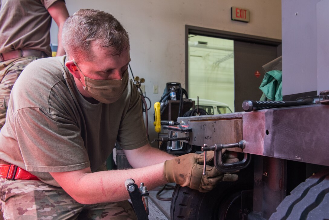 Senior Airman Jay Powell, 22nd Maintenance Squadron metals technology journeyman, positions a C-clamp on a mobile aircraft generator July 9, 2020, at McConnell Air Force Base, Kansas. Powell was using the clamp to hold the repair piece in place prior to welding. (U.S. Air Force photo by Airman 1st Class Marc A. Garcia)