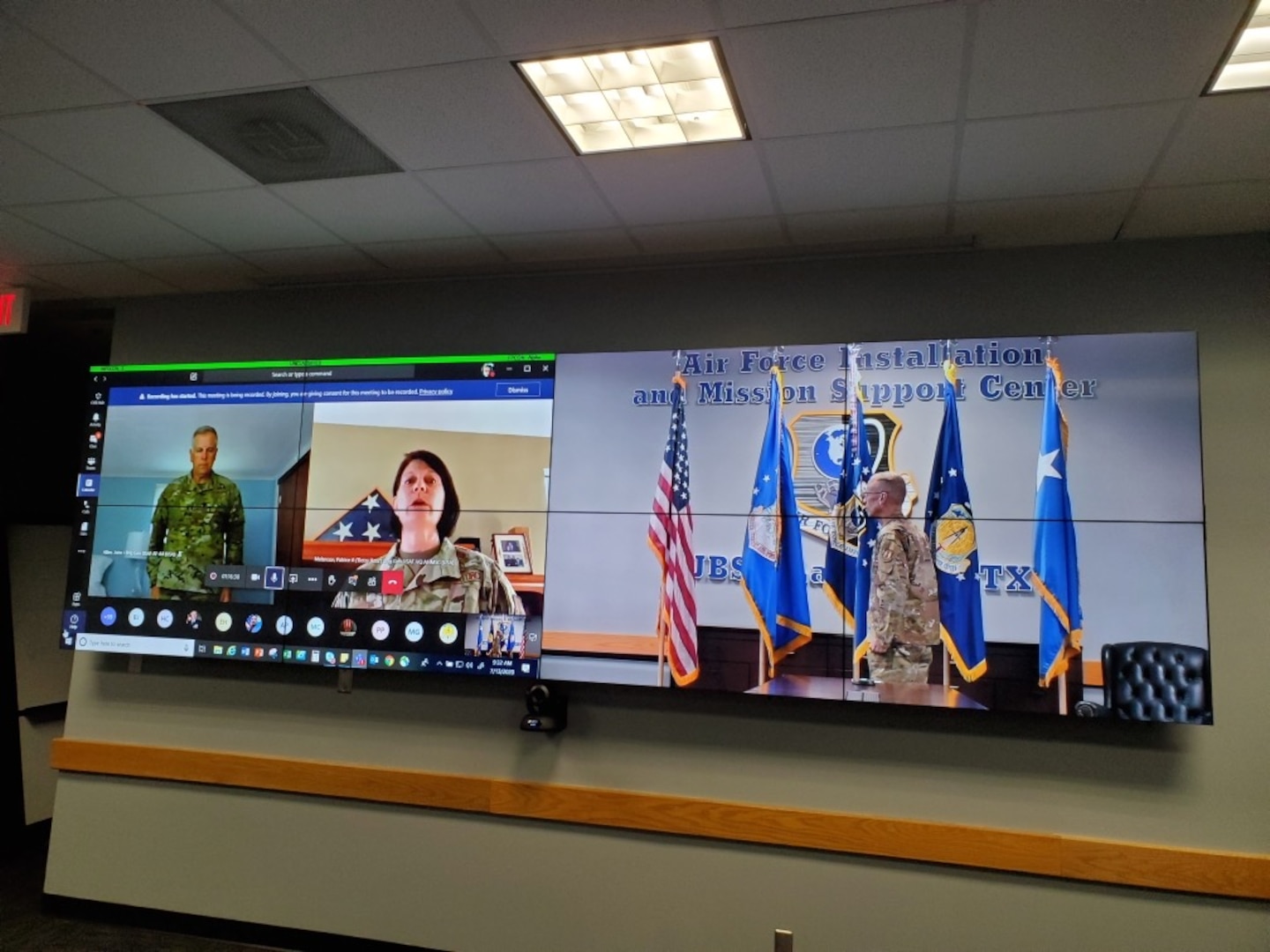 Photo of Brig. Gen. Patrice Melancon singing national anthem as Brig. Gen. John Allen and Maj. Gen. Tom Wilcox look on.