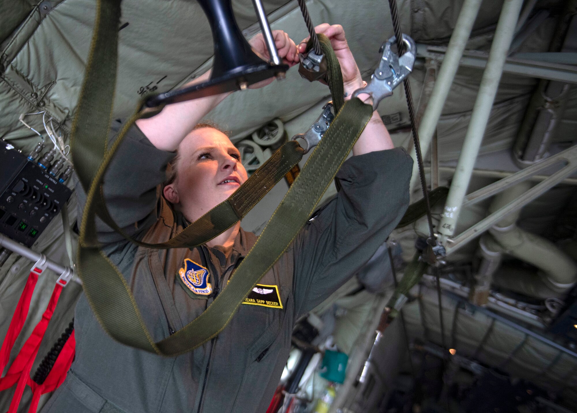 Staff Sgt. Teara Becker, 36th Airlift Squadron loadmaster, attaches a static line retrieval system