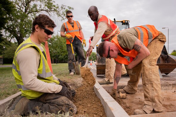 Staff Sgt. Jeffrey Elwell, 100th Civil Engineer Squadron heavy equipment horizontal engineer supervisor, measures a curb at RAF Mildenhall, England, July 12, 2020. The 100th CES Pavements and Construction Equipment Section, whose members are known as Dirt Boyz, removed vehicle barriers and fencing to improve base infrastructure. (U.S. Air Force photo by Airman 1st Class Joseph Barron)
