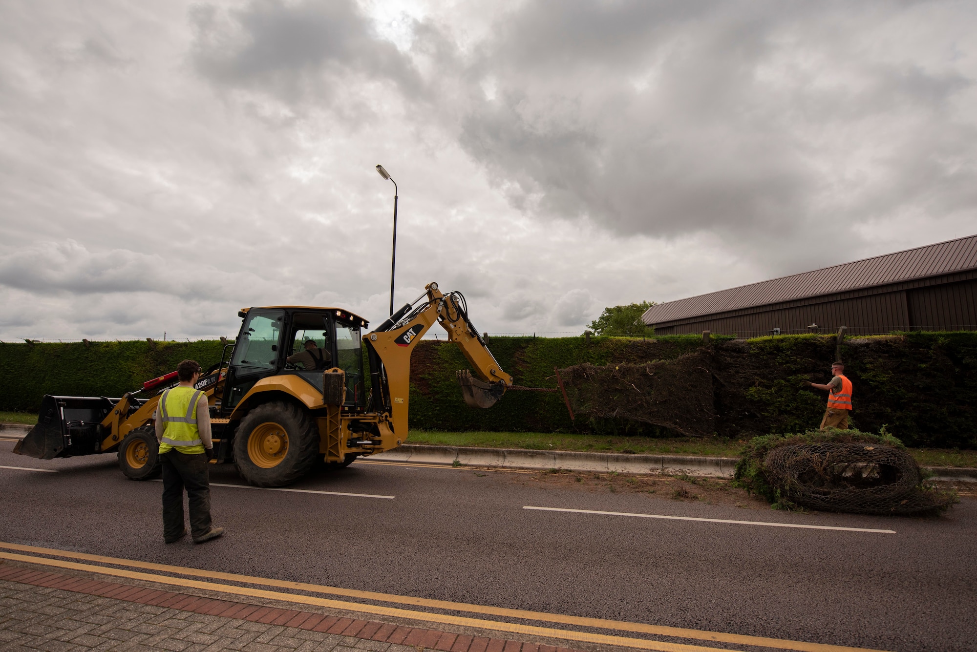 Airmen with the 100th Civil Engineer Squadron Pavement and Construction Equipment Section, remove hedge fencing along Lincoln Road at RAF Mildenhall, England, July 13, 2020. The fencing was removed to improve pedestrian access to parking. (U.S. Air Force photo by Airman 1st Class Joseph Barron)