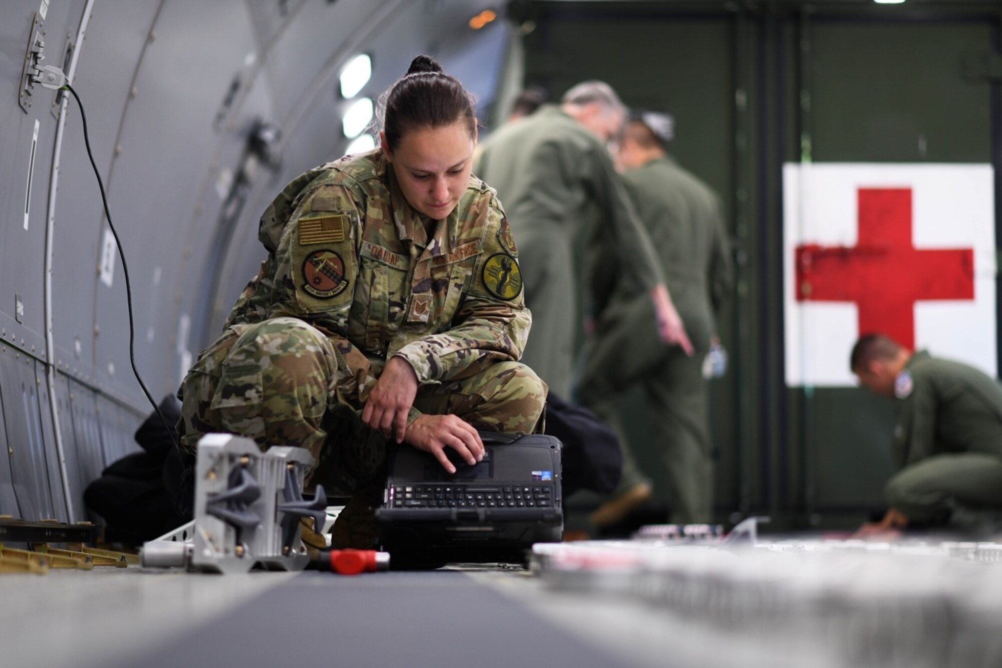Tech. Sgt. Leah Oakleaf, 931st Aircraft Maintenance Squadron crew chief assigned to McConnell Air Force Base, Kansas reviews her technical order for configuration plans of the fuselage cargo palette locks July 11, 2020 at Travis Air Force Base, California. Rapid response from vendors to create quality replacement for parts such as cargo locks and outlets played a key role in resolving deficiencies that previously withheld the KC-46A Pegasus from operating as an aeromedical evacuation aircraft.  (U.S. Air Force photo by Airman 1st Class Nilsa Garcia)