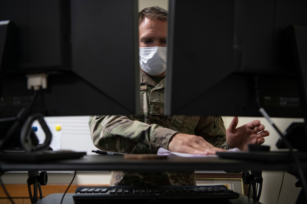 An airman sanitizes his work space.