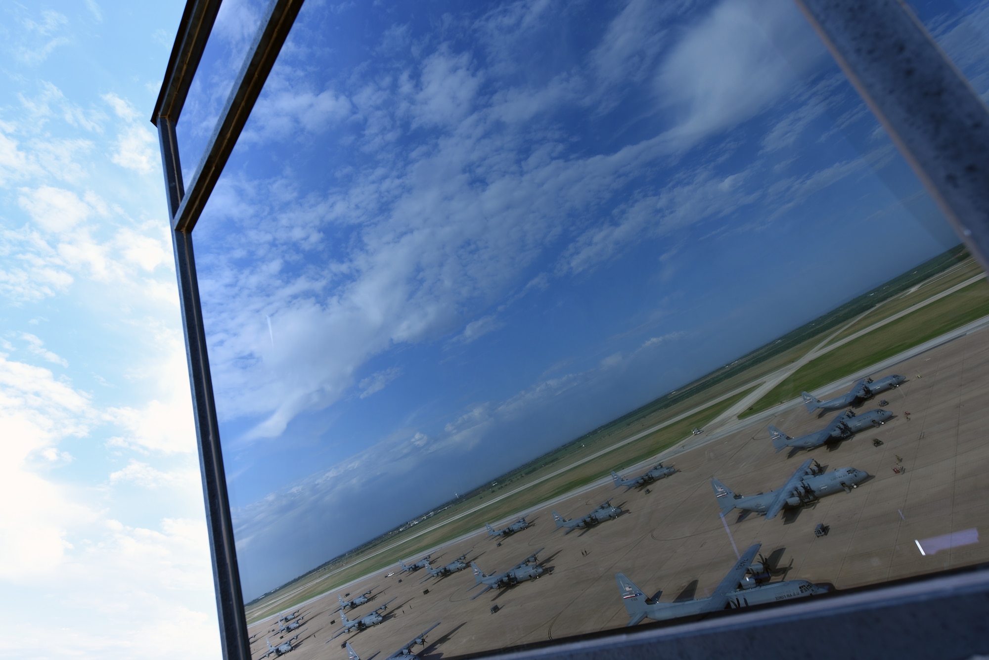 A view of C-130J Super Hercules aircraft belonging to the 317th Airlift Wing reflect in the window of the Air Traffic Control Tower at Dyess Air Force Base, July 14, 2020.