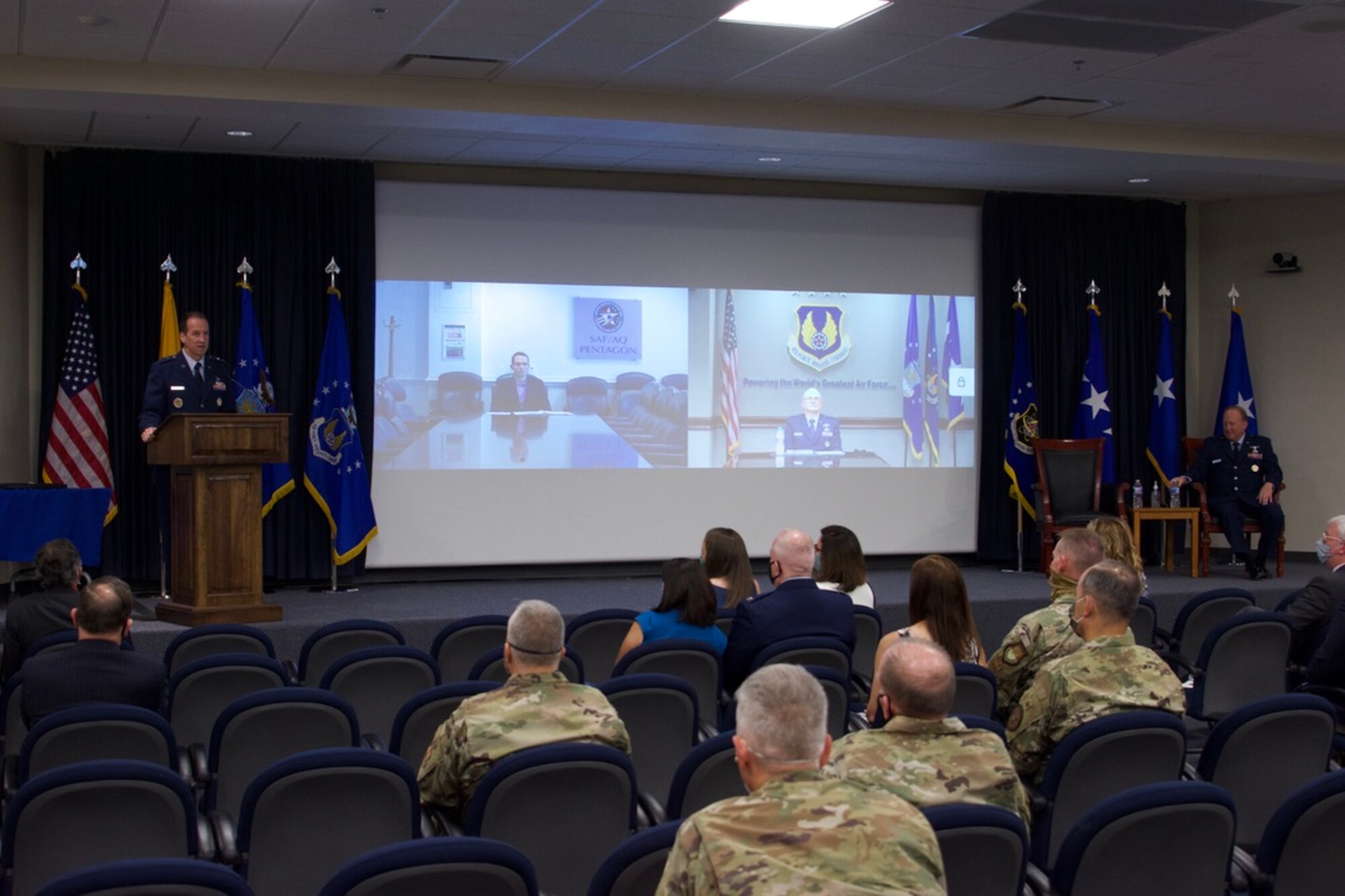 Brig. Gen. Anthony W. “Awgie” Genatempo, right, took command of the Air Force Nuclear Weapons Center during a ceremony June 26 at Kirtland AFB, New Mexico. He succeeds Maj. Gen. Shaun Q. Morris, left, who took command of AFNWC in October 2017. Gen. Arnold W. Bunch, Jr., commander, Air Force Materiel Command, on right of screen projection, virtually presided over the center’s change-of-command ceremony. Dr. Will Roper, Air Force assistant secretary for acquisition, technology and logistics, on left of screen, virtually presided over the change in leadership for the Air Force program executive officer for strategic systems, a dual-hatted position for the center commander. (Air Force photos by Capt. Matthew Rice)