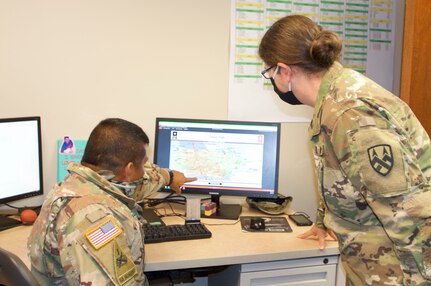 Chief Warrant Officer 4 Dorian Bozza (left), senior maintenance technician at the 377th Theater Sustainment Command, discusses operational planning with Sgt. Maj. Susan Curtis, 377th TSC chief personnel noncommissioned officer, at the command headquarters in Belle Chasse, La.