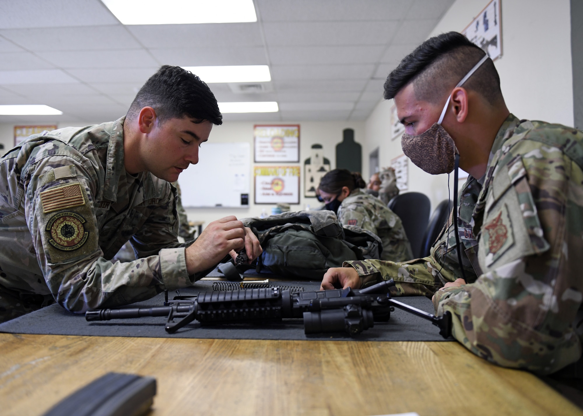 Tech. Sgt. Chad Choker, NCOIC of combat arms (left), assists a student during a Combat Arms Training and Maintenance course, June 22, 2020, at Beale Air Force Base, California. CATM instructors teach Airmen how to properly use, disassemble, and clean a weapon safely. (U.S. Air Force photo by Airman 1st Class Luis A. Ruiz-Vazquez)