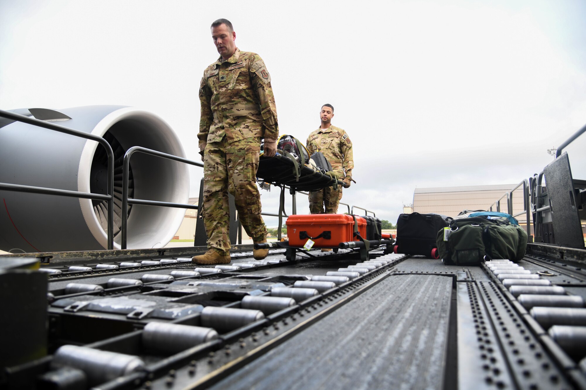 Lt. Col Jason Arndt, 133rd Airlift Wing flight nurse assigned to the Minnesota Air National Guard Base and Staff Sgt. Jeremy Gregory, 145th Airlift Wing aeromedical evacuation technician assigned to the North Carolina Air National Guard Base, carry a litter containing in-flight medical equipment July 10, 2020, at Joint Base Andrews, Maryland. The mission originated at Joint Base Andrews and transited a total of five patients and two attendees to Naval Station Norfolk, Virginia; Patrick AFB, Florida; and Travis AFB, California. (U.S. Air Force photo by Airman 1st Class Nilsa Garcia)