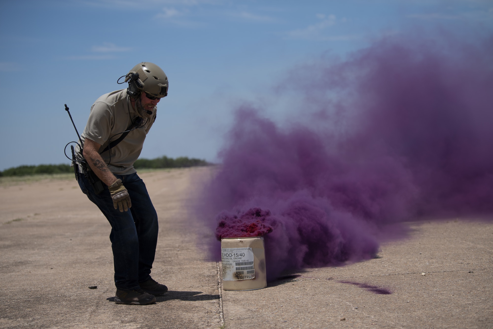 Casey Jones, 317th Operations Support Squadron drop zone and loading zone controller, ignites violet M18 Smoke Grenades in West Texas, July 14, 2020.