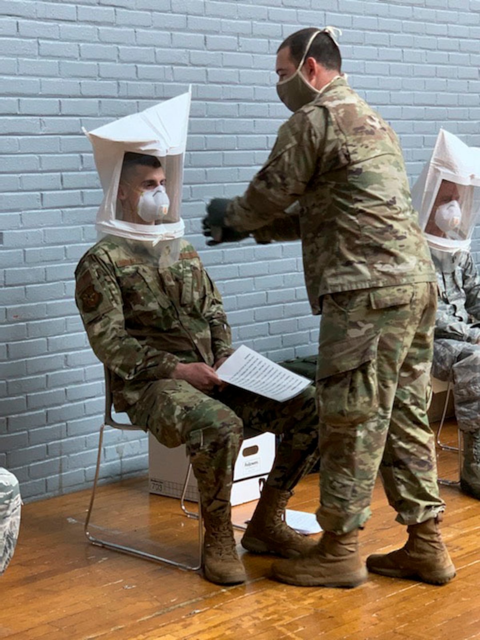 Soldiers getting fitted for a Tyvek suit.