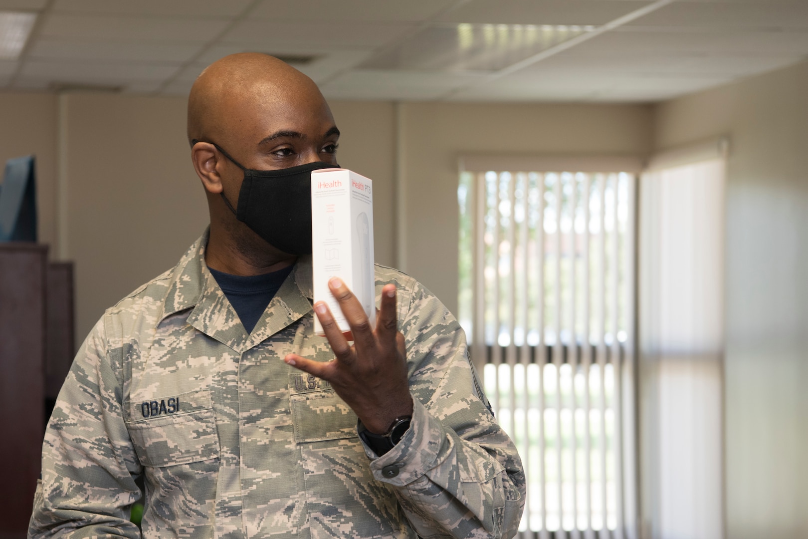 An Airman holds up a box to others