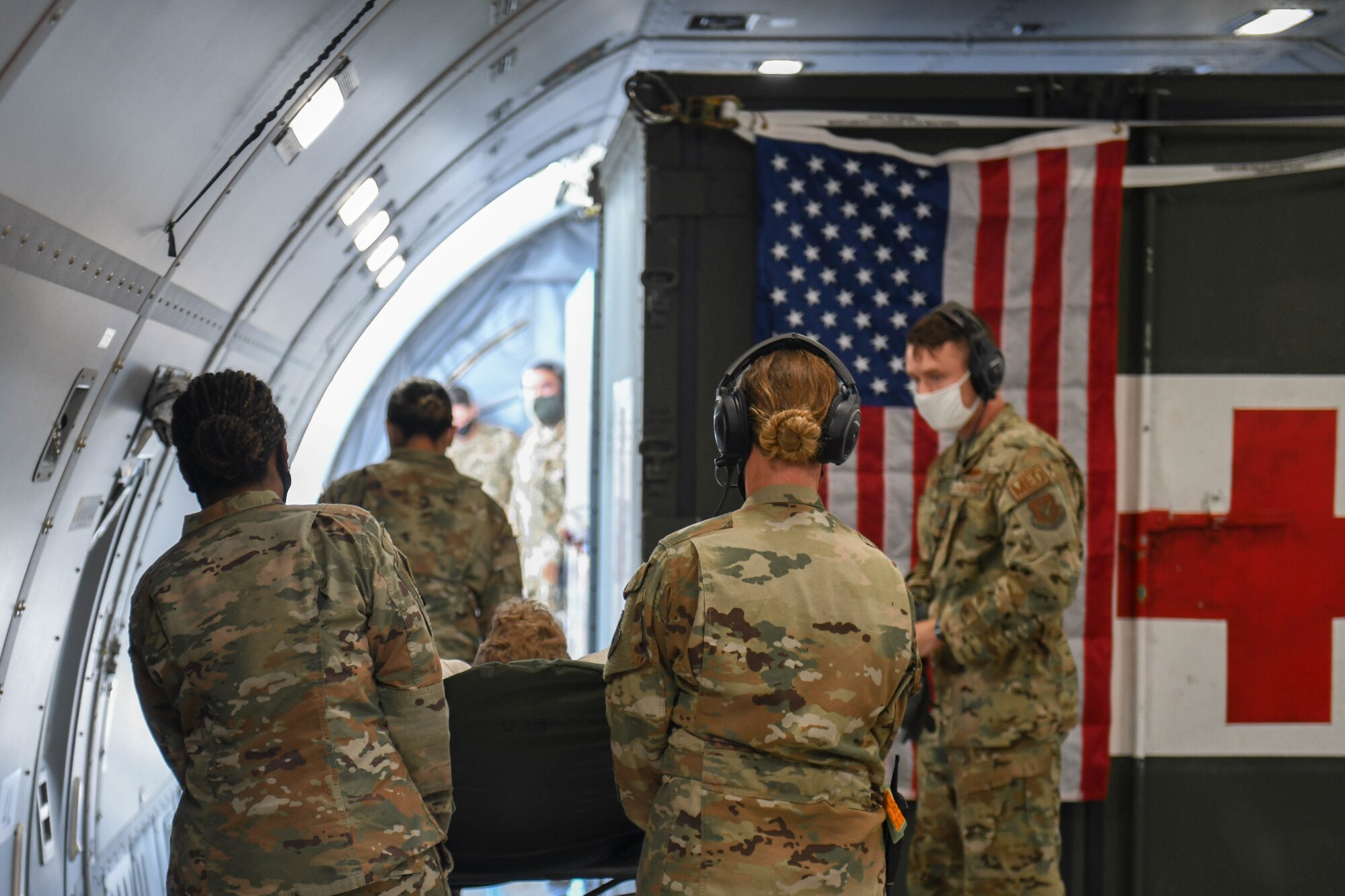 Photo of Airmen offloading a non-ambulatory patient.